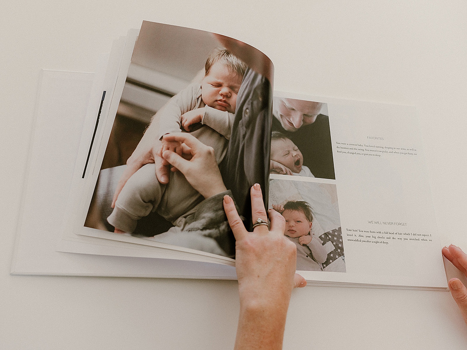 A person opens a custom baby book made with a memory book app.