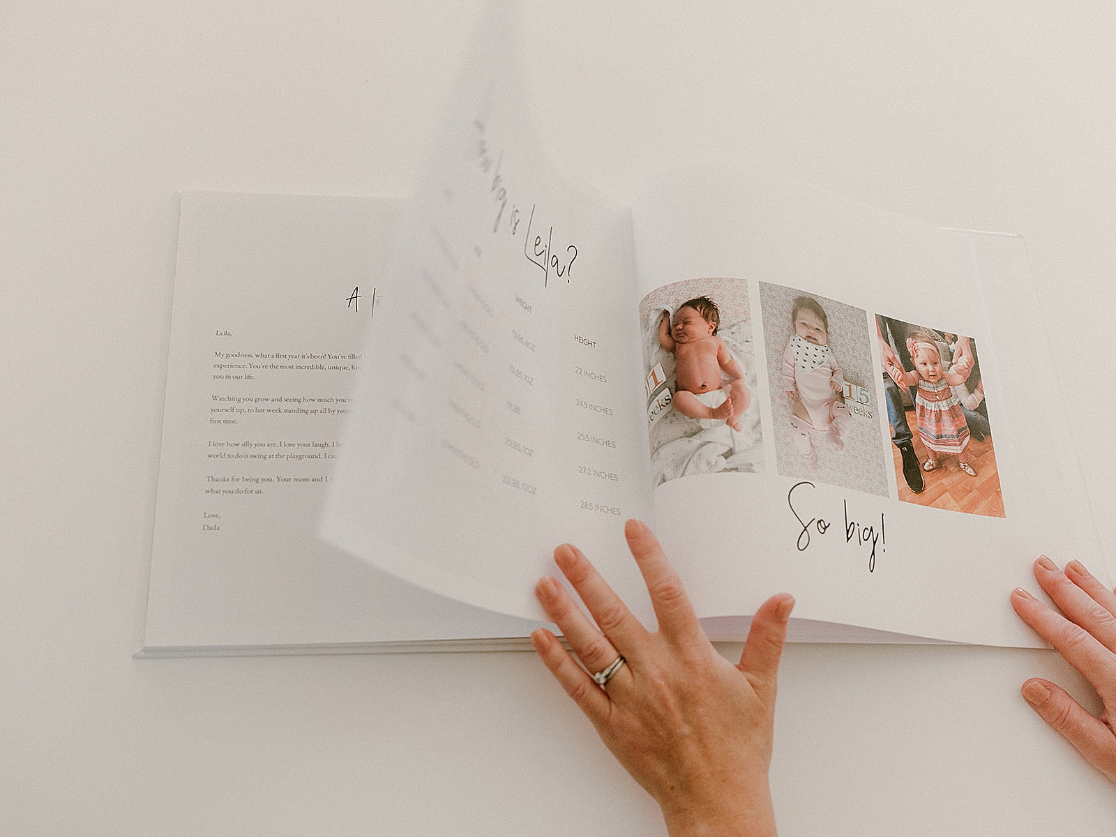 A woman flips through a baby milestone book created on a memory book app.