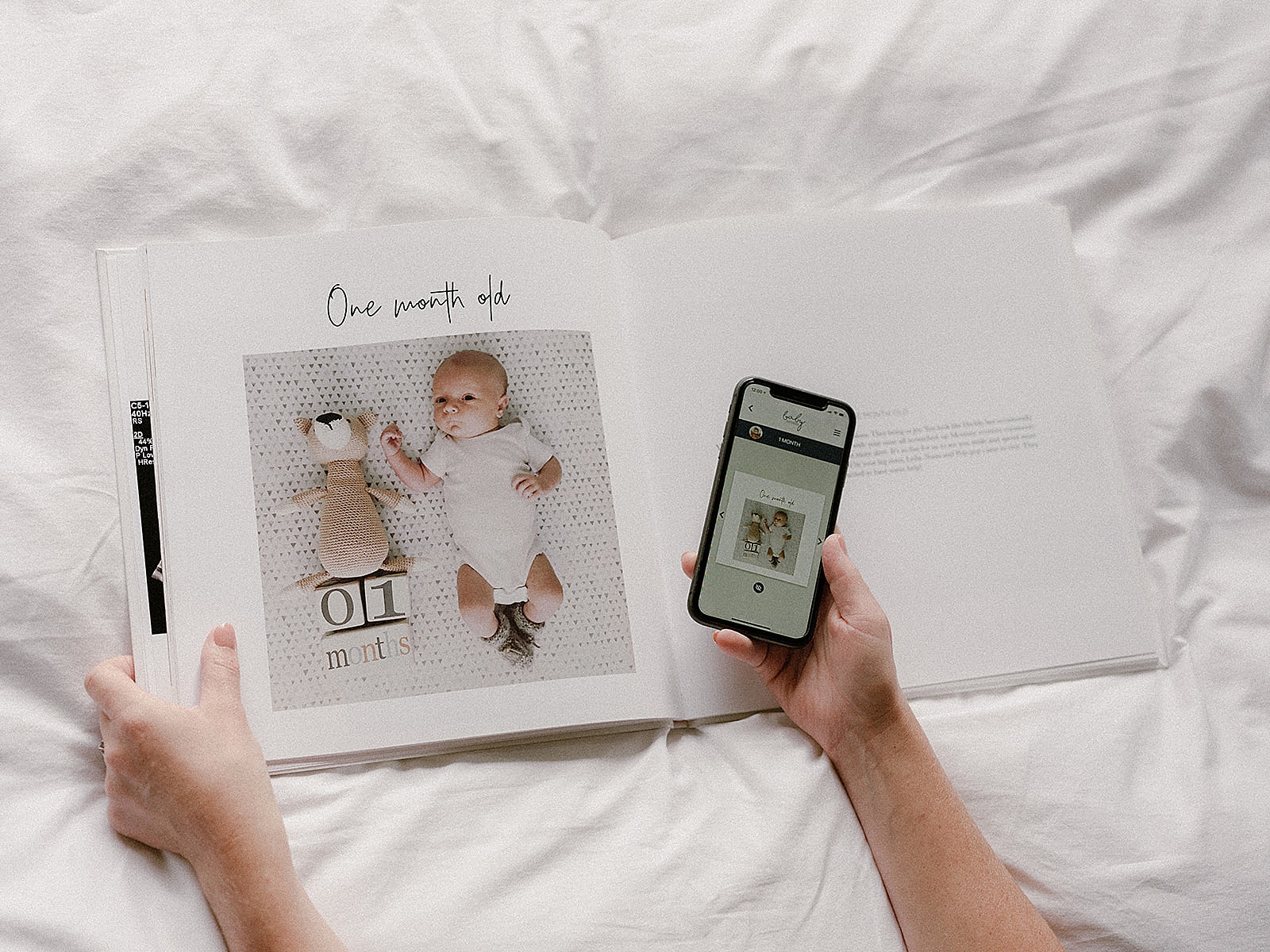 A phone shows a digital baby book beside a printed book.