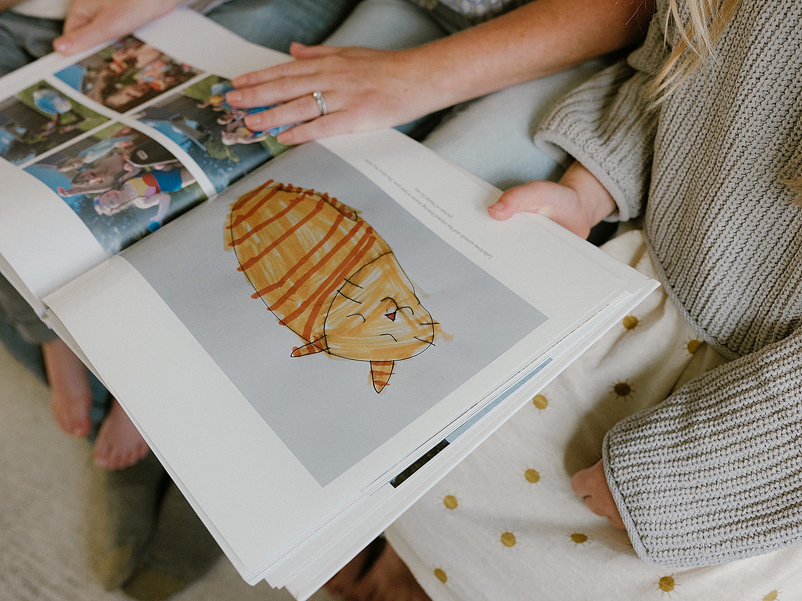 A family looks through a photo album that includes pictures of children's artwork.