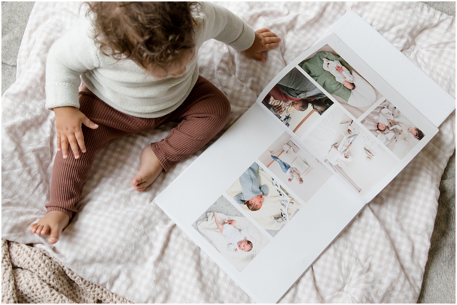 A toddler flips through a Baby Book made with Baby Notebook instead of Qeepsake.