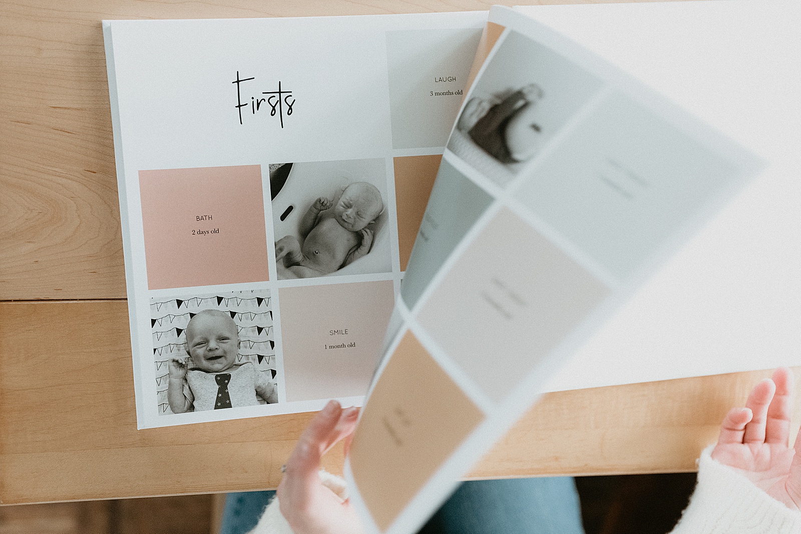 A woman flips through a baby milestone book with a layout of firsts and photos.