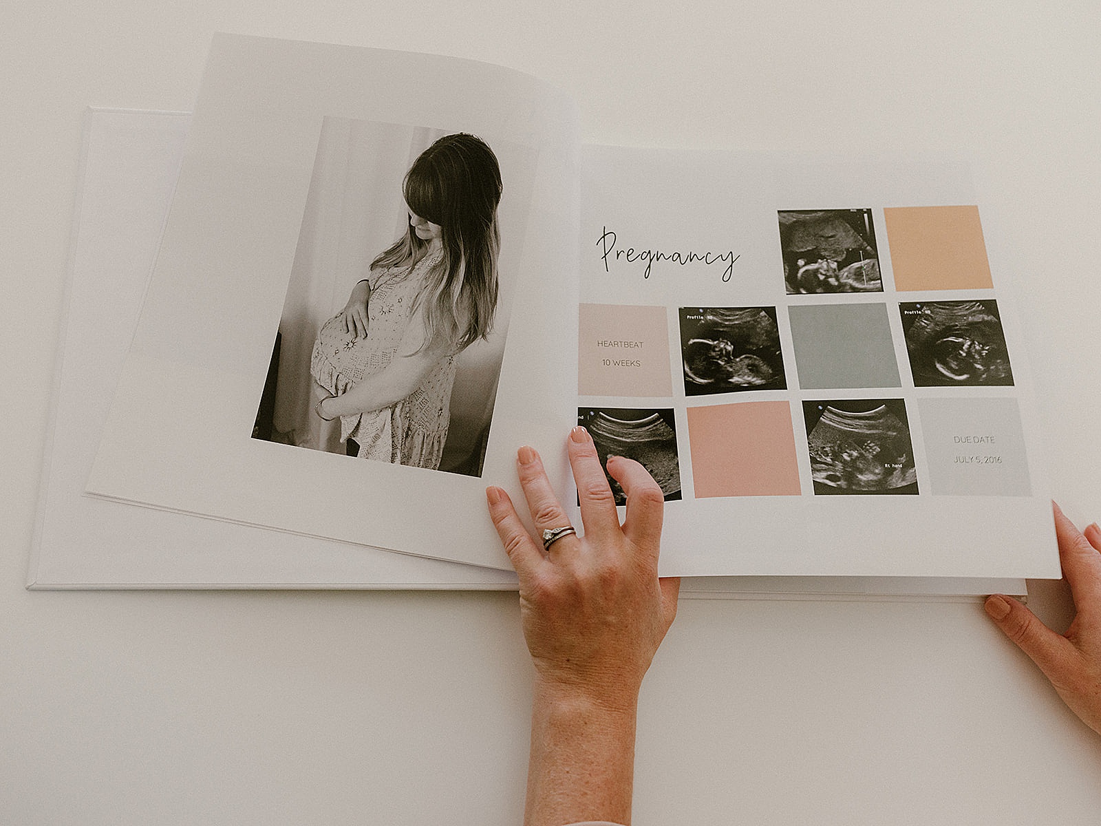 A woman sets a milestone book on a white table.