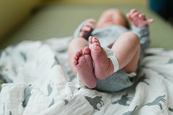 A close up of a baby's feet with a hospital bracelet on her ankle for fresh 48 photos