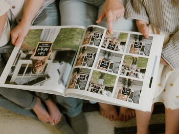 A parent points to a picture in a family yearbook created in a keepsake app.