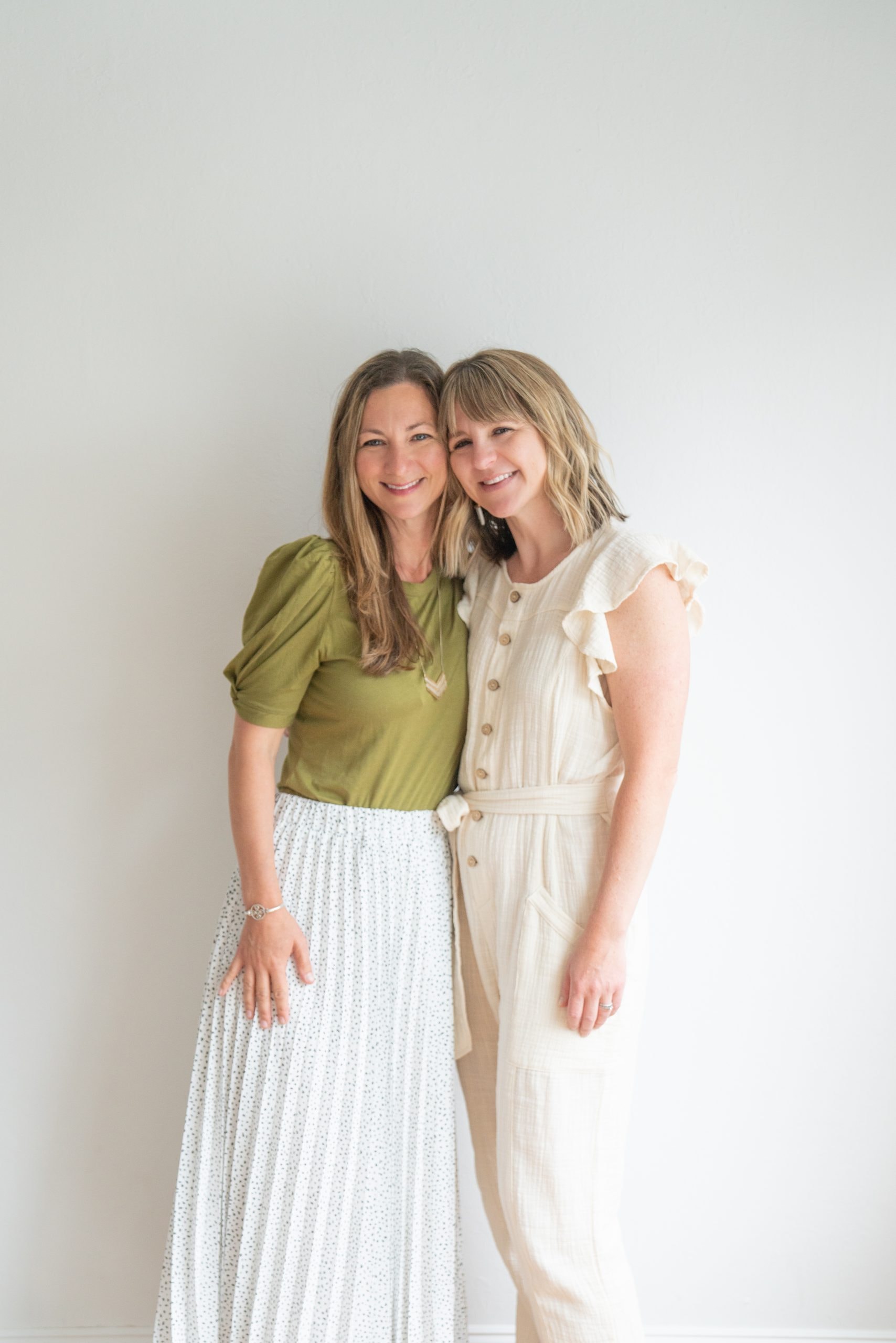 Two moms standing together who are sisters and co-founders of the baby book app